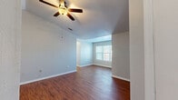 Located at 301 N Gross Rd in Kingsland, Georgia, this single-story, 3-bedroom, 2-bathroom home offers a well-organized and functional layout. The open-concept living, dining, and kitchen area serves as the heart of the home, characterized by rich hardwood-style flooring, vaulted ceilings, and ceiling fans that promote comfortable airflow. Natural light filters in through window blinds, brightening the neutral gray walls throughout.

The kitchen features warm honey-toned cabinetry, a stainless steel range, and a peninsula with a white countertop that opens seamlessly to the living and dining areas — ideal for everyday use and entertaining. The transition from the main living space into the hallways and bedrooms is clean and well-defined.

All three bedrooms are carpeted for comfort and each includes a ceiling fan and window. The primary bedroom offers a generous footprint with direct closet access. Four closets in total provide ample storage across the home.

Both bathrooms are finished with wood-style flooring, wood-toned vanity cabinetry, white countertops, and tub-shower combinations with tiled surrounds. A dedicated laundry room with washer/dryer hookups and overhead wire shelving, along with a separate utility room, rounds out the practical features of this well-appointed home.
