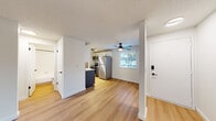 This single-floor unit offers a clean, modern aesthetic with thoughtful updates throughout. The open-concept living and dining area is anchored by light hardwood-style flooring, a textured ceiling, and a ceiling fan that enhances airflow and comfort. A sliding glass door connects the living space to an outdoor balcony, filling the room with natural light and providing pleasant views of surrounding greenery.

The galley-style kitchen is well-equipped with white upper cabinetry, navy blue lower cabinets, white quartz countertops, a classic subway tile backsplash, and a matte black pull-down faucet over an undermount sink. Stainless steel appliances, including a full-size refrigerator, range, and microwave, complete the kitchen. Track lighting overhead illuminates the workspace efficiently.

The bedroom features soft wall-to-wall carpeting, a baseboard heater, and a window with blinds that allow in ample natural light while maintaining privacy. The full bathroom is cleanly finished with a tub/shower combination, white fixtures, a framed mirror with black hardware, and a single-sink vanity. The unit also includes a smart lock entry door and offers a bright, move-in-ready environment throughout.
