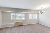 Located at 700 Sligo Ave in Silver Spring, MD, this single-floor, 2-bedroom, 1-bathroom residence offers a practical and well-laid-out living space. The combined living and dining area is generously sized, featuring plush wall-to-wall carpeting, neutral-toned walls, and multiple windows that allow natural light to fill the room. A wall-mounted HVAC unit provides convenient climate control throughout the space.

The galley-style kitchen is a standout feature, outfitted with white shaker cabinetry, granite countertops, a stainless steel sink, a gas range, an in-unit washer, and wood-look flooring. Track lighting illuminates the workspace, making it both functional and visually appealing.

Both bedrooms are carpeted and bright, each equipped with a wall HVAC unit and window views of the surrounding greenery. The primary bedroom is notably spacious and includes a dedicated closet. The second bedroom also features closet access and is connected to the hallway. Three closets throughout the unit provide ample storage.

The bathroom is clean and bright, featuring a full tub-shower combination with tiled surround, a single vanity with white cabinetry, and a large mirror. The overall aesthetic of the residence is light, neutral, and move-in ready.