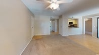 This single-floor residence offers a thoughtfully designed layout that balances comfort and functionality throughout. The spacious living area serves as the heart of the home, anchored by a tile-surround fireplace and bathed in natural light from multiple windows dressed with vertical blinds. A ceiling fan overhead and neutral-toned carpet underfoot create a warm, inviting atmosphere, while light hardwood-style flooring transitions seamlessly into adjoining areas.

The kitchen is efficiently designed with white cabinetry, a dark laminate countertop, and a full suite of black appliances including a range, built-in microwave, and dishwasher. A skylight above adds a bright, airy feel to the cooking space.

The bedrooms are generously proportioned, each featuring plush carpeting, ceiling fans with light fixtures, and textured ceilings. Sliding glass doors in one bedroom open to the outdoors, while another bedroom connects directly to a vanity area complete with white cabinetry, a dark countertop, and a large mirrored medicine cabinet. Closets with sliding doors provide ample storage.

The bathrooms are clean and functional, each equipped with a full-size soaking tub and shower combination set within a white surround. Overall, the space presents a practical and comfortable layout with consistent neutral tones throughout.