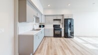 Located at 3100 S Bascom Ave in San Jose, CA, this one-bedroom, one-bathroom unit offers a well-organized single-level layout with a clean, modern aesthetic throughout. Light wood-tone flooring runs continuously across the space, lending warmth and visual cohesion to every room.

The kitchen is a standout feature, outfitted with sleek grey cabinetry extending to the ceiling, a marble-style tile backsplash, white quartz countertops, a stainless steel sink, and black appliances including a gas range and full-size refrigerator. Recessed lighting and light wood floors give the kitchen a contemporary and functional feel.

The bedroom is a comfortable, light-filled room featuring a window fitted with blinds, a wall-mounted HVAC unit, and a sliding-door closet with built-in rod and shelving for efficient storage. Neutral white walls and natural light streaming through the window create a calm, airy atmosphere.

The bathroom is finished with small-format mosaic tile flooring, a grey vanity with an integrated sink and mirror, and a toilet. The space is neatly laid out and well-lit.

Overall, the unit presents a cohesive, modern design with practical finishes throughout, making it a functional and comfortable living space in San Jose's Cambrian neighborhood.