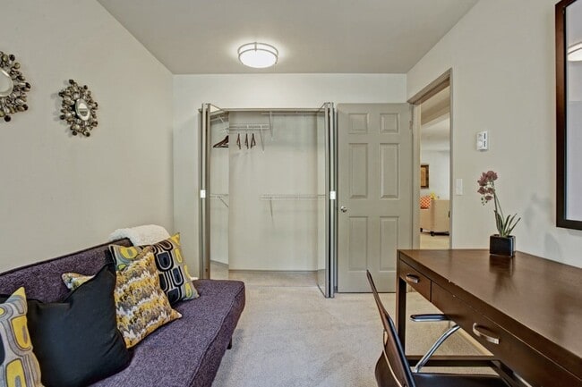A bedroom used as a home office with a daybed, desk and chair, bookshelves, and a large window - Windsong