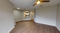 This single-story residence offers a thoughtfully designed layout with a warm, neutral color palette throughout. The open living and dining areas are finished with durable wood-look plank flooring, textured ceilings, and recessed lighting, creating a bright and functional space. A chair rail detail adds a classic touch to the main living area, which also benefits from natural light through blinds-fitted windows.

The kitchen is well-equipped with white shaker-style cabinetry, light quartz countertops, a subway tile backsplash, and stainless steel appliances including a range and over-the-range microwave. An arched pass-through connects the kitchen to the living area, enhancing the open feel. A walk-in pantry with wire shelving provides ample storage.

Bedrooms are carpeted for comfort and include ceiling fans and windows that bring in natural light. The primary bedroom features an en-suite bathroom with a double-sink vanity, white cabinetry, and a tiled tub-shower combination. A second full bathroom mirrors the same clean, updated aesthetic. A dedicated laundry area accommodates a full-size washer and dryer, completing this practical and cohesive home.