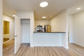 This thoughtfully designed 2-bedroom, 2-bathroom unit at 72 South Essex Avenue in Orange, NJ offers a clean, contemporary living experience across a single floor. Light-toned luxury vinyl plank flooring runs throughout, lending a cohesive and modern aesthetic to every room. The open-concept kitchen features a peninsula with a dark countertop, cream cabinetry, subway tile backsplash, and a full suite of stainless steel appliances including a refrigerator, microwave, and range. A dedicated electrical panel is conveniently accessible near the kitchen area. The living area flows naturally from the kitchen and offers easy access to a coat closet. Both bedrooms are bright and well-proportioned, with large black-framed windows that frame views of the surrounding urban streetscape and allow ample natural light. The primary bedroom includes a generously sized walk-in closet outfitted with wire shelving and built-in drawer storage. The two bathrooms are finished in neutral large-format tile, each featuring a soaking tub/shower combination with chrome fixtures and modern vanities with undermount sinks. A dedicated in-unit laundry room and a utility room add practical convenience. The unit presents a clean, move-in-ready interior with a consistent modern design palette throughout.