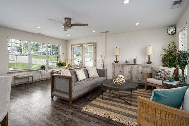 Gather in our welcoming clubhouse featuring comfortable seating and coffee table for socializing, professionally operated by Highlands Vista Group. - Arbours at Victoria Place