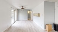 Located at 5900 Enterprise Ct in El Paso, TX, this single-floor, one-bedroom, one-bathroom unit offers a well-organized and functional layout. The open living area features light wood-style flooring and a neutral white color palette that creates a bright, airy atmosphere. A ceiling fan anchors the living space, which flows seamlessly into the kitchen via a convenient pass-through window. The kitchen is outfitted with white cabinetry, granite-look speckled countertops, brushed nickel hardware, and matching light wood-style flooring, providing a clean and cohesive aesthetic. The bedroom is finished with plush carpet and features dual windows dressed with blinds, filling the room with natural light. A ceiling fan with light fixture adds comfort, while a dedicated closet offers practical storage. The bathroom is well-appointed with a wide granite-look vanity countertop, white cabinetry, a large mirror with multi-bulb vanity lighting, and a tiled tub-shower combination. Textured walls throughout add subtle depth to the space. The unit's efficient design, consistent finishes, and bright, neutral tones make it a practical and comfortable living space.