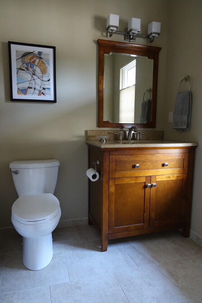 Baño completo con tocador y espejo sobre el lavabo. - 2620 Tallant Rd