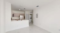 Located at 1451 W 29th St in Hialeah, FL, this 2-bedroom, 2-bathroom unit offers a clean, modern aesthetic throughout. The open-concept kitchen and living area serves as the heart of the home, featuring a peninsula with a built-in sink, taupe cabinetry with ample storage, stainless steel appliances including a refrigerator, range, and microwave, and a seamless flow into the living space. Polished marble-look tile flooring runs throughout the entire unit, lending a bright and cohesive feel to every room. A dedicated in-unit laundry area with a stacked washer and dryer adds everyday convenience. Both bedrooms are well-proportioned and bathed in natural light from sliding windows that offer views of the surrounding community. Each room features crisp white walls and the same elegant tile flooring, creating a fresh, move-in-ready environment. The two bathrooms are finished in a consistent white palette, with tiled tub-shower combos, vanities with under-sink storage, and illuminated mirrors. Two closets provide practical storage solutions, while a private balcony extends the living space outdoors. The unit also includes a hallway connecting all areas efficiently, completing a thoughtfully laid-out and well-appointed floor plan.