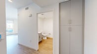 Located at 8811 Sepulveda Blvd in Los Angeles, CA, this efficiently designed studio unit offers a clean, modern aesthetic throughout its single-floor layout. The combined kitchen and living area forms the heart of the space, featuring light wood-tone flooring, recessed lighting, and a sleek galley-style kitchen equipped with stainless steel appliances—including a gas range, refrigerator, and dishwasher—complemented by contemporary gray cabinetry, white quartz countertops, and a double-basin sink with a brushed gold faucet. The living area benefits from two large windows fitted with roller shades, allowing abundant natural light to fill the room while providing views of the surrounding neighborhood. The full bathroom is finished in a clean, white palette with light wood flooring, a vanity with under-cabinet storage, and accessibility-friendly grab bars, reflecting a thoughtful and functional design. Two closets offer practical built-in storage, with tall, floor-to-ceiling cabinetry providing ample organization space. A dedicated entrance completes the layout. Throughout the unit, consistent light flooring, white walls, and a neutral color palette create a bright, cohesive, and modern living environment.