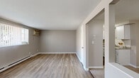 Located at 85 Paradise Ln in Tonawanda, NY, this one-bedroom, one-bathroom unit offers a practical and well-appointed single-floor layout. The living room is a welcoming space featuring light wood-style flooring, neutral gray walls, a wall-mounted air conditioning unit, and baseboard heating. Large windows invite an abundance of natural light, offering views of the surrounding neighborhood. An adjacent dining area provides a seamless transition into the galley-style kitchen, which is outfitted with white cabinetry, granite-look countertops, a subway tile backsplash, a stainless steel double sink, and a stainless steel refrigerator. The bedroom features plush carpeting, a sliding double-door closet, baseboard heating, and a window for natural light. A hallway connects the main living areas and includes access to two closets, offering ample storage. The full bathroom is efficiently designed with a white vanity, a toilet, and a tub-shower combination. Throughout the unit, a consistent neutral color palette and clean finishes create a cohesive and move-in-ready atmosphere suitable for comfortable everyday living.