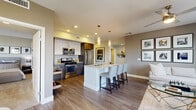 Located at 1110 W Town and Country Rd in Orange, CA, this thoughtfully designed 2-bedroom, 4-bathroom residence offers a seamless blend of modern aesthetics and functional living. Rich hardwood-style flooring flows throughout the open-concept main living area, connecting the kitchen, dining, and living spaces with ease. The kitchen is outfitted with stainless steel appliances, dark wood cabinetry, white upper cabinets, and a sleek island with a quartz countertop and pendant lighting overhead — ideal for casual dining or entertaining. The adjacent dining area benefits from floor-to-ceiling glass doors that open to a balcony, flooding the space with natural light and offering open views of the surrounding area. A ceiling fan anchors the living room, adding to the comfortable ambiance. The primary bedroom provides a well-proportioned retreat with plush carpeting, while the bathrooms are finished with wood-toned vanities, subway tile accents, quartz countertops, and a combination soaking tub and glass-enclosed shower. A dedicated laundry room includes a full-size washer and dryer with overhead cabinetry for additional storage. Two closets and a clean hallway entry complete the well-organized layout of this polished Orange County residence.