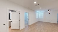 Located on Space Age Road in Madison, Alabama, this single-floor unit offers a clean, modern aesthetic throughout. Light wood-style flooring extends across the main living areas, complemented by crisp white walls and recessed lighting that create a bright, open atmosphere. Natural light filters in through multiple windows fitted with horizontal blinds, enhancing the airy feel of each room.

The kitchen is well-equipped with white shaker cabinetry, stainless steel appliances including a range, microwave, and dishwasher, and a decorative arabesque tile backsplash that adds a stylish detail to the space. Light countertops provide ample prep surface throughout.

The bedrooms feature plush carpet flooring, large windows, and ceiling fans, offering comfortable, functional spaces. One bedroom connects to a spacious walk-in closet outfitted with double hanging rods and shelving, providing generous storage capacity.

The full bathroom includes a combined tub and shower unit, a single-sink vanity with sage-toned cabinetry and light countertops, a framed mirror, and contrasting gray accent walls. A second bathroom area is also accessible, offering added convenience. The unit's overall design prioritizes clean lines, neutral tones, and practical finishes throughout.