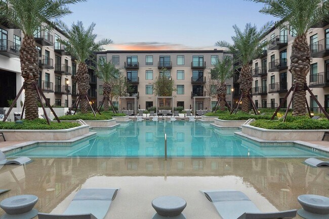 Piscina inspirada en un resort con cabañas junto a la piscina y tumbonas dentro de la piscina. - The Sterling at Regent Square