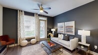 Located in Richardson, TX, this thoughtfully designed one-bedroom, one-bathroom residence offers an efficient and stylish single-floor layout. The open-concept kitchen flows seamlessly into the living area, anchored by dark espresso cabinetry, granite countertops, a peninsula island with seating, stainless steel appliances, a tile backsplash, and elegant pendant lighting overhead. Recessed lighting and track lighting add a polished, modern touch.

The living room is a standout space, featuring rich hardwood-style flooring, bold navy accent walls, a ceiling fan, and large windows that invite abundant natural light. A glass sliding door provides access to outdoor views, while patterned drapes and framed wall art contribute to the room's refined character.

The bedroom offers a serene retreat with plush carpet, generous window views of the surrounding greenery, a ceiling fan, and ample space for furnishings. A walk-in closet connects directly to the bathroom, which includes a dark-cabinetry vanity with a white countertop, a glass-enclosed shower, tile flooring, and clean, neutral finishes throughout. This residence combines contemporary design with functional comfort.