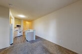 Located at 4656 Quigg Dr in Santa Rosa, CA, this single-floor, one-bedroom, one-bathroom residence offers a practical and well-organized layout across a compact but functional footprint. The entrance leads into an open-concept living and kitchen area, where hardwood-style flooring runs through the kitchen and transitions to plush carpet in the living space. The kitchen is equipped with a gas range, over-the-range microwave, refrigerator, dishwasher, and a double-basin sink set into a peninsula-style counter that helps delineate the cooking and living zones. Light-toned cabinetry provides generous storage throughout. The living area is bright and airy, benefiting from a sliding glass door that opens to a private balcony, allowing natural light to flow in and offering outdoor views. The bedroom is a comfortable, carpeted retreat with two windows that invite additional natural light and include two closets for ample storage. The full bathroom features a tiled tub-shower combination with a grab bar and tile surround. A dedicated utility room rounds out the interior, adding practical functionality. The unit's neutral palette and clean finishes create a calm, move-in-ready atmosphere throughout.