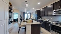 Located in Grand Prairie, TX, this well-appointed one-bedroom, one-bathroom residence offers a thoughtfully designed open-concept layout that maximizes its footprint. Light wood-look flooring flows throughout the main living areas, creating a cohesive and modern aesthetic.

The kitchen is a standout feature, boasting rich dark cabinetry, gleaming granite countertops, stainless steel appliances — including a French door refrigerator — and a large center island with bar seating, illuminated by striking globe pendant lights. The kitchen connects seamlessly to the living area, which is bathed in natural light from large windows with views to an outdoor balcony, and is equipped with a ceiling fan.

The bedroom offers a calm, carpeted retreat with ample natural light filtering through window treatments. It connects directly to a full bathroom featuring dark cabinetry, granite countertops, and wood-look flooring, which in turn leads to a well-organized walk-in closet with built-in shelving and hanging rods on multiple sides. Recessed lighting and clean white walls throughout contribute to a bright and contemporary ambiance, making this residence an efficient yet refined living space.