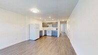 This single-floor, 2-bedroom, 1-bathroom residence in Brighton, Colorado offers a clean, modern aesthetic with a consistent design language carried throughout every room. The interior is finished with durable wood-look plank flooring and crisp white walls, creating a bright and cohesive atmosphere.

The kitchen is a functional centerpiece, featuring gray shaker-style cabinetry, light countertops, recessed lighting, and white appliances including a refrigerator, range, and dishwasher. It flows conveniently into the living area, which offers recessed lighting and ample space for everyday living.

Both bedrooms are well-sized, each featuring wood-look flooring, neutral white walls, and natural light from windows with blinds. The primary bedroom includes a built-in closet with bifold doors and views of the surrounding neighborhood. The second bedroom also features a closet with bifold doors, maintaining the same clean, functional style.

The bathroom is neatly appointed with a gray shaker-style vanity, a large mirror with overhead lighting, a full tub/shower combination, and coordinating wood-look flooring that ties the space together.

Throughout the residence, clean lines, neutral tones, and thoughtful detailing provide a move-in ready environment well-suited for comfortable daily living in Brighton, CO.