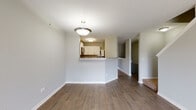 Located at 487 Vinings Dr in Bloomingdale, Illinois, this two-floor home offers a well-organized layout with distinct living zones across both levels. The main floor features an open-concept design where the living area flows naturally toward the kitchen, separated by a half-wall peninsula with granite-style countertops. This breakfast bar functions as both a visual divider and a casual dining surface. The kitchen is well-appointed with white shaker cabinetry, a grey subway tile backsplash, light stone countertops, and stainless steel appliances including a range and over-the-range microwave. Light wood-look tile flooring runs throughout the kitchen, while the living and dining areas showcase rich, dark hardwood-style flooring. A sliding glass door in the living room provides outdoor access and allows natural light to fill the space. A staircase leads to the upper level, where carpeted bedrooms offer a comfortable retreat. The primary bedroom includes a large window with neighborhood views and access to a walk-in closet. The primary bathroom features a dual-sink vanity with ample cabinetry, wood-look flooring, and a separate tiled tub and shower area. The overall aesthetic is clean and modern, with neutral tones throughout.