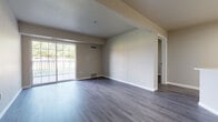 This single-floor, two-bedroom, two-bathroom residence in West Jordan, Utah, offers a clean, modern aesthetic with thoughtfully selected finishes throughout. The open-concept living and dining area is anchored by wide-plank gray vinyl flooring that flows seamlessly through the entire unit. A large sliding glass door fills the living space with natural light while providing direct access to an outdoor balcony, offering views of the surrounding landscape.

The kitchen features white shaker-style cabinetry with black hardware, crisp quartz countertops, a geometric tile backsplash, and stainless steel appliances including a range and over-the-range microwave. A peninsula with a sleek black faucet bridges the kitchen and living area, creating a functional open layout. An in-unit laundry area with bi-fold doors adds everyday convenience.

Both bedrooms are well-proportioned, each equipped with ceiling fans and plantation shutters that allow for adjustable natural light and privacy. The two full bathrooms mirror each other in design, each featuring a tub-shower combination, white vanity with black hardware, and coordinating gray vinyl flooring, maintaining the unit's cohesive modern style.