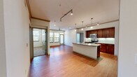 This two-story residence offers a thoughtfully designed layout across two floors, providing a comfortable and functional living experience. The main living area showcases warm hardwood flooring that flows seamlessly from the open-concept living room into the kitchen, creating a cohesive and inviting space. Crown molding and track lighting add refined architectural detail throughout.

The kitchen is a standout feature, equipped with rich dark-wood cabinetry, granite countertops, a classic white subway tile backsplash, stainless steel appliances including a side-by-side refrigerator and range, and a central island with pendant lighting — ideal for both cooking and entertaining.

The living room is bright and airy, benefiting from multiple windows that invite natural light and views of the surrounding area. A ceiling fan adds both comfort and style.

Both bedrooms are carpeted and feature ceiling fans with light fixtures. The primary bedroom connects to an en-suite bathroom with a tiled walk-in shower, while two generously sized closets with wire shelving provide ample storage throughout. The second bedroom also enjoys natural light through a window with exterior views.

The lower floor includes an attached single-car garage with an automatic opener. Two staircases connect the levels, enhancing the home's overall flow and accessibility.