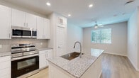 Located on Brittmoore Road in Houston, TX, this thoughtfully designed one-bedroom, two-bathroom home offers a clean, modern aesthetic across a single level. Light wood flooring flows throughout, complementing the bright, neutral color palette that gives the space an open and airy feel.

The kitchen is a standout feature, boasting a central island with a granite countertop and undermount sink, crisp white cabinetry, a subway tile backsplash, and a full suite of stainless steel appliances including a refrigerator with ice maker, range, microwave, and dishwasher. A stacked washer and dryer is conveniently tucked nearby. Recessed lighting illuminates the kitchen, which opens to the living area, enhancing the sense of connectivity and flow.

The living room features a ceiling fan and a large window that invites natural light and outdoor views. The bedroom is a comfortable retreat, also equipped with a ceiling fan and windows with exterior views.

Both bathrooms are finished with granite vanity tops and white cabinetry. One bathroom features a soaking tub framed by elegant marble-style tile surround. The primary bathroom includes direct access to a dedicated walk-in closet with built-in shelving and rod storage, adding practical organization to the space.