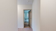 Located at 161 S Huntington Ave in Boston's Jamaica Plain neighborhood, this well-designed two-bedroom, two-bathroom residence offers a thoughtful single-floor layout with modern finishes throughout. The open living area is bathed in natural light from large, floor-to-ceiling windows that frame views of the surrounding cityscape, and is finished with light hardwood flooring that lends a clean, contemporary feel.

The kitchen is outfitted with white shaker cabinetry reaching to the ceiling, granite countertops, and a full suite of stainless steel GE appliances including a range, microwave, dishwasher, and refrigerator — providing both style and function.

Both bedrooms are comfortably sized and carpeted for warmth, each featuring windows with urban views and ample wall space. The primary bedroom offers a generous footprint with access to natural light. The second bedroom also benefits from bright windows overlooking the street.

The two bathrooms are finished in a clean, neutral palette. One features a walk-in glass-enclosed tiled shower with a white vanity, while the second includes a soaking tub with classic white subway tile surround. Light tile flooring and well-lit mirrors complete each bathroom.

Connecting the rooms are two hallways finished with hardwood floors, contributing to the cohesive and modern feel of this well-appointed Boston residence.