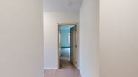 Located at 161 S Huntington Ave in Boston's Jamaica Plain neighborhood, this well-designed two-bedroom, two-bathroom residence offers a thoughtful single-floor layout with modern finishes throughout. The open living area is bathed in natural light from large, floor-to-ceiling windows that frame views of the surrounding cityscape, and is finished with light hardwood flooring that lends a clean, contemporary feel.

The kitchen is outfitted with white shaker cabinetry reaching to the ceiling, granite countertops, and a full suite of stainless steel GE appliances including a range, microwave, dishwasher, and refrigerator — providing both style and function.

Both bedrooms are comfortably sized and carpeted for warmth, each featuring windows with urban views and ample wall space. The primary bedroom offers a generous footprint with access to natural light. The second bedroom also benefits from bright windows overlooking the street.

The two bathrooms are finished in a clean, neutral palette. One features a walk-in glass-enclosed tiled shower with a white vanity, while the second includes a soaking tub with classic white subway tile surround. Light tile flooring and well-lit mirrors complete each bathroom.

Connecting the rooms are two hallways finished with hardwood floors, contributing to the cohesive and modern feel of this well-appointed Boston residence.
