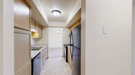 Located at 1090 Links Ct in Brookfield, Wisconsin, this single-floor residence offers three bedrooms, three bathrooms, a kitchen, hallway, and a dedicated closet. The layout is thoughtfully organized to maximize functionality throughout.

The expansive primary bedroom stands out as the centerpiece of the home, featuring plush carpeting, soft neutral walls, and multiple windows fitted with blinds that invite natural light while maintaining privacy. A large sliding-door closet provides generous storage, and a dedicated en-suite bathroom is conveniently accessible.

The two additional bedrooms are well-proportioned, each finished with the same warm carpeting and cream-toned walls, and benefit from windows that bring in natural daylight.

The galley-style kitchen features light wood cabinetry, a tiled floor, a stainless steel refrigerator, and black appliances including a range and dishwasher. A chandelier overhead adds a touch of warmth, and the kitchen opens toward the adjoining living area.

The three bathrooms are finished with light tile flooring and warm wood vanities topped with solid-surface countertops. Fixtures include sconce lighting and classic hardware. One bathroom features a full tub-shower combination.

Throughout the home, a consistent palette of soft whites and warm neutrals creates a clean, cohesive ambiance well-suited for comfortable everyday living.
