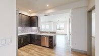Located at 3727 S Bentley Ave in Los Angeles, this modern 3-bedroom, 2-bathroom home offers a thoughtfully designed single-floor layout. The open-concept kitchen is a standout feature, boasting rich dark-wood cabinetry, a mosaic tile backsplash, white quartz countertops, and a full suite of stainless steel appliances including a gas range, built-in microwave, dishwasher, and a French door refrigerator. Light wood-style flooring runs throughout the main living areas, complementing the clean, contemporary aesthetic. The spacious living room is bathed in natural light, with large sliding glass doors opening to a private balcony that offers open views of the surrounding Los Angeles neighborhood. A stylish pendant light fixture anchors the dining area. Each bedroom features plush carpeting and dedicated closets, with the secondary bedrooms enjoying large windows with exterior views. Both bathrooms are finished with large-format tile flooring, marble-topped dark wood vanities, oversized backlit mirrors, and glass-enclosed tub-shower combinations. The home also includes a connecting hallway providing seamless access to all rooms, creating a practical and well-organized flow throughout.