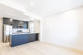 Located at 271 Madison Ave S in Kitchener, Ontario, this thoughtfully designed unit offers three bedrooms and one bathroom across a single floor. The open-concept kitchen and living area serves as the heart of the space, anchored by a sleek central island with a crisp white quartz countertop and a matte black faucet. The kitchen features dark navy cabinetry accented with gold hardware, stainless steel appliances, and a double undermount sink positioned beneath a bright window overlooking the neighbourhood. Recessed lighting throughout ensures a clean, modern aesthetic, while light-toned hardwood flooring runs seamlessly across all rooms, enhancing the sense of openness.

The three bedrooms are finished in soft white tones with the same light hardwood flooring and feature windows that bring in natural light and neighbourhood views. The primary bedroom benefits from dual windows, adding extra brightness to the space. The compact but efficient bathroom showcases a glass-enclosed shower with elegant marble-effect tile surround, a contemporary toilet, and a stone-topped vanity. Throughout the unit, crisp white walls, clean lines, and modern fixtures combine to create a bright, minimalist atmosphere that is both functional and inviting.