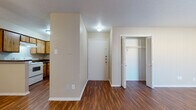 This single-floor unit offers a well-organized layout highlighted by rich, wood-style flooring that runs consistently throughout every room, creating a cohesive and warm aesthetic. The living area is generously proportioned, bathed in ambient light, and features a ceiling fan for added comfort. A dedicated closet with louvered bifold doors provides convenient storage directly off the main living space.

The kitchen is designed for functionality, featuring warm wood-toned cabinetry that extends to the upper and lower levels, dark countertops, and a peninsula-style breakfast bar that separates the kitchen from the living area. White appliances, including a refrigerator and dishwasher, complement the layout, and a sink with overhead cabinetry rounds out the practical workspace.

The bedroom is a comfortable, well-sized retreat with its own ceiling fan, textured ceiling, and two louvered bifold closet doors offering generous storage capacity. The bathroom is clean and straightforward, featuring a tiled tub-shower combination, hardwood-style flooring, a toilet, and a vanity with dark countertop. Throughout the unit, neutral-toned walls, textured ceilings, and consistent flooring tie the spaces together into a practical and livable home.
