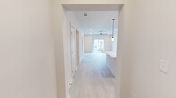 Located in Toccoa, GA, this single-story, 3-bedroom, 3-bathroom home offers a thoughtfully designed modern interior with a clean, neutral aesthetic throughout. Light wood-style flooring flows seamlessly across all rooms, complementing the bright white walls and creating a cohesive, airy feel. The kitchen is a standout feature, equipped with stainless steel appliances, a center island with a white quartz countertop and pendant lighting, floor-to-ceiling white upper cabinetry, and contrasting dark wood-toned lower cabinets with matte black hardware. The spacious primary bedroom features a ceiling fan, sliding glass doors that open to an outdoor balcony with neighborhood views, and direct access to a private bathroom. Additional bedrooms are well-proportioned, each with ceiling fans and ample natural light from large windows. All three bathrooms are finished in a consistent modern style, featuring subway-tiled tub-surround combinations, dark wood-tone vanities with white quartz countertops, and matte black fixtures and hardware. One bathroom includes a compact single-vanity layout ideal for guests. The home also includes a dedicated entrance, hallway, and closet, ensuring functional flow throughout the single-floor layout.
