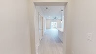 Located in Toccoa, GA, this single-story, 3-bedroom, 3-bathroom home offers a thoughtfully designed modern interior with a clean, neutral aesthetic throughout. Light wood-style flooring flows seamlessly across all rooms, complementing the bright white walls and creating a cohesive, airy feel. The kitchen is a standout feature, equipped with stainless steel appliances, a center island with a white quartz countertop and pendant lighting, floor-to-ceiling white upper cabinetry, and contrasting dark wood-toned lower cabinets with matte black hardware. The spacious primary bedroom features a ceiling fan, sliding glass doors that open to an outdoor balcony with neighborhood views, and direct access to a private bathroom. Additional bedrooms are well-proportioned, each with ceiling fans and ample natural light from large windows. All three bathrooms are finished in a consistent modern style, featuring subway-tiled tub-surround combinations, dark wood-tone vanities with white quartz countertops, and matte black fixtures and hardware. One bathroom includes a compact single-vanity layout ideal for guests. The home also includes a dedicated entrance, hallway, and closet, ensuring functional flow throughout the single-floor layout.