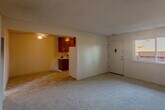 Located at 924 Mangrove Ave in Sunnyvale, CA, this 2-bedroom, 1-bathroom unit offers a straightforward single-floor layout designed for efficient everyday living. The living room features neutral carpet flooring, warm beige walls, a textured ceiling, and a ceiling fan, creating a simple and functional common area. A wall-mounted heating unit provides climate control throughout the space. The kitchen is laid out in a galley style, featuring rich wood cabinetry with ample upper and lower storage, a double-basin sink, light tile flooring, and a window that allows natural light to brighten the workspace. A white refrigerator and range are included. Both bedrooms are carpeted, finished with neutral walls and textured ceilings, and each includes a built-in wall heater. The primary bedroom offers a comfortable footprint with natural light provided by a window overlooking the exterior. The second bedroom similarly benefits from neutral tones and practical proportions. The bathroom includes a full tub and shower combination with white tile surround, a window for ventilation and light, and a toilet. A hallway connects the rooms, completing the functional layout of this Sunnyvale unit.