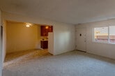 Located at 924 Mangrove Ave in Sunnyvale, CA, this 2-bedroom, 1-bathroom unit offers a straightforward single-floor layout designed for efficient everyday living. The living room features neutral carpet flooring, warm beige walls, a textured ceiling, and a ceiling fan, creating a simple and functional common area. A wall-mounted heating unit provides climate control throughout the space. The kitchen is laid out in a galley style, featuring rich wood cabinetry with ample upper and lower storage, a double-basin sink, light tile flooring, and a window that allows natural light to brighten the workspace. A white refrigerator and range are included. Both bedrooms are carpeted, finished with neutral walls and textured ceilings, and each includes a built-in wall heater. The primary bedroom offers a comfortable footprint with natural light provided by a window overlooking the exterior. The second bedroom similarly benefits from neutral tones and practical proportions. The bathroom includes a full tub and shower combination with white tile surround, a window for ventilation and light, and a toilet. A hallway connects the rooms, completing the functional layout of this Sunnyvale unit.