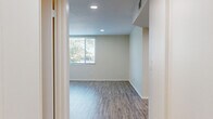 Located at 5505 Zelzah Ave in Encino, Los Angeles, this two-story residence offers 2 bedrooms and 3 bathrooms spread across two thoughtfully arranged floors. The lower level features a bright living area with light wood-style flooring, recessed lighting, and a window that draws in natural light. The kitchen stands out with white cabinetry, marble-inspired tile backsplash, quartz countertops, stainless steel appliances including a gas range, built-in microwave, dishwasher, and refrigerator, all set on wood-style flooring. The bathrooms are finished with quartz countertops, undermount sinks, white cabinetry, and clean tile flooring, offering a consistent modern aesthetic throughout. Upstairs, both bedrooms are carpeted and feature mirrored sliding closet doors that enhance the sense of space. The primary bedroom includes multiple windows with views of the surrounding greenery, while the second bedroom opens via sliding glass doors to a private outdoor area, filling the room with natural light. Connecting hallways and a staircase link both levels efficiently. The overall design is clean and neutral, with a palette of soft whites and warm beiges that create a calm, functional living environment.
