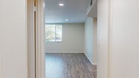 Located at 5505 Zelzah Ave in Encino, Los Angeles, this two-story residence offers 2 bedrooms and 3 bathrooms spread across two thoughtfully arranged floors. The lower level features a bright living area with light wood-style flooring, recessed lighting, and a window that draws in natural light. The kitchen stands out with white cabinetry, marble-inspired tile backsplash, quartz countertops, stainless steel appliances including a gas range, built-in microwave, dishwasher, and refrigerator, all set on wood-style flooring. The bathrooms are finished with quartz countertops, undermount sinks, white cabinetry, and clean tile flooring, offering a consistent modern aesthetic throughout. Upstairs, both bedrooms are carpeted and feature mirrored sliding closet doors that enhance the sense of space. The primary bedroom includes multiple windows with views of the surrounding greenery, while the second bedroom opens via sliding glass doors to a private outdoor area, filling the room with natural light. Connecting hallways and a staircase link both levels efficiently. The overall design is clean and neutral, with a palette of soft whites and warm beiges that create a calm, functional living environment.