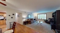 This single-floor home offers a thoughtfully arranged layout with distinct living, dining, kitchen, and bedroom spaces. The living room is generously sized, featuring plush carpeting, neutral walls, and a large bay window with wood trim that allows abundant natural light to fill the space. A dedicated entertainment wall provides ample storage and display space alongside the main seating area.

The dining area transitions seamlessly from the living space, featuring hardwood flooring, a ceiling fan with integrated lighting, and a closet for additional storage. The kitchen is well-equipped with warm wood cabinetry, bold black granite countertops, and stainless steel appliances including a gas range and over-the-range microwave, all set above durable hardwood floors.

The bedrooms are carpeted and spacious, each featuring ceiling fans with light fixtures and windows that invite natural light. Neutral tones throughout create a calm, comfortable atmosphere. The bathroom includes a combination tub and shower, tile flooring, and a vanity with dark granite countertops and wood cabinetry, complemented by a large double-door closet. Overall, the home presents a practical and cohesive design with consistent finishes throughout.