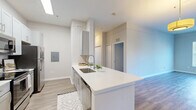 Located at 3550 Esplanade Way in Tallahassee, FL, this single-floor, 3-bedroom, 2-bathroom residence offers a thoughtfully designed layout with contemporary finishes throughout. The open-concept kitchen and living area serves as the heart of the home, featuring sleek gray shaker cabinetry, white quartz countertops, a stainless steel appliance suite including a range, microwave, and refrigerator, and a large peninsula with an undermount sink — ideal for both cooking and casual dining. Wood-look flooring flows seamlessly throughout the entire space, lending a clean, cohesive aesthetic.

Each of the three bedrooms is generously proportioned, with the spacious primary bedroom offering ample room for furnishings. All bedrooms are fitted with ceiling fans, large windows with blinds that bring in abundant natural light, and views of surrounding greenery. Two dedicated closets provide convenient storage.

The two bathrooms are finished with white vanities, quartz countertops, and shower-tub combinations with curtained enclosures, maintaining the home's clean, modern style. Neutral gray-toned walls throughout create a bright and welcoming ambiance, making this a comfortable and functional living space.