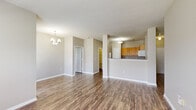 Located at 6810 Valley Ridge Dr in Indianapolis, Indiana, this single-floor, three-bedroom, two-bathroom home offers a well-organized and functional layout. Dark hardwood-style flooring flows consistently throughout the home, providing a cohesive and clean aesthetic against neutral gray walls and crisp white trim.

The open-concept living and kitchen area serves as the heart of the home. The spacious living room features an elegant chandelier and connects seamlessly to the kitchen, which is equipped with warm honey-toned cabinetry, gray laminate countertops, a stainless steel sink, and white appliances including a range, over-the-range microwave, and refrigerator. A breakfast bar-style peninsula separates the two spaces, making it ideal for casual dining or entertaining.

The primary bedroom is generously proportioned and includes a walk-in closet outfitted with wire shelving and organizational racks for ample storage. The two additional bedrooms each feature natural light from windows overlooking the outdoors. Both bathrooms are equipped with single-sink vanities with gray countertops and a tub/shower combination with tiled surround.

A dedicated laundry room with hookups and built-in shelving adds everyday convenience. Three closets throughout the home provide additional storage. The layout is practical and efficient, making this a comfortable residence in Indianapolis.