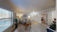Located at 3903 SE Military Dr in San Antonio, Texas, this single-floor residence offers a thoughtfully designed layout that balances comfort and functionality. The living room serves as the heart of the home, featuring light wood-style flooring, soft neutral walls, and a welcoming ambiance enhanced by warm accent lighting. A decorative wall sculpture adds a modern artistic touch, while a window allows natural light to filter in through blinds.

The adjacent dining area is brightened by a large window overlooking greenery outside, creating a pleasant setting for meals. Light wood-style flooring continues seamlessly from the living space into this area, reinforcing a cohesive design throughout the common areas.

The kitchen is equipped with stainless steel appliances, including a range and microwave, complemented by white cabinetry and light countertops. A double-basin stainless steel sink sits at the peninsula, which opens toward the living and entry areas for an accessible, connected feel.

The bedroom features plush carpeting, a ceiling fan with integrated lighting, and a window that brings in natural light. The neutral color palette and clean lines throughout the space create a calm, restful environment. Additional wall art and thoughtful décor details contribute to a polished and inviting atmosphere across the entire residence.