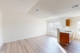 Located at 11201 Partnership Lane in Manassas, VA, this 3-bedroom, 2-bathroom unit offers a thoughtfully arranged single-floor layout designed for comfortable everyday living. The open-concept living and dining area features light-toned wood-look flooring and vaulted ceilings that lend an airy sense of height and spaciousness. Natural light flows in through large windows, creating a bright and welcoming atmosphere throughout the main living space.

The kitchen is positioned adjacent to the living area and features warm oak-toned cabinetry, a peninsula with a built-in sink, a black electric range, white refrigerator, and overhead range hood — all supported by tile countertops and additional upper cabinet storage. A window above the sink provides natural light to the workspace.

The primary bedroom includes vaulted ceilings, a ceiling fan, and plush carpeting, with access to a closet and an adjoining bathroom. The additional bedrooms are carpeted and feature windows with views of the surrounding exterior, along with individual closets. With six closets total, storage is plentiful throughout the unit.

The bathrooms are clean and functional, with one featuring a full tub-shower combination and wood-look flooring. A dedicated laundry area includes washer/dryer hookups and wire shelving overhead, adding everyday convenience to this well-organized home.