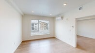 Located at 6988 N Nevada St in Spokane, Washington, this two-bedroom, one-bathroom residence offers a thoughtfully designed layout that maximizes every square foot. Light hardwood flooring runs consistently throughout the unit, creating a warm and cohesive feel from room to room.

The kitchen is a standout feature, equipped with a full suite of stainless steel appliances including a refrigerator, electric range, over-the-range microwave, and dishwasher. Warm wood-tone flat-front cabinetry extends to the ceiling, providing ample storage, while a classic subway tile backsplash and recessed lighting add a clean, modern aesthetic. The open layout connects the kitchen directly to the living area, making the space feel open and functional.

Both bedrooms are bright and well-proportioned, each featuring windows that allow natural light and views of the surrounding neighborhood. The primary bedroom includes a sliding-door closet and a wall-mounted mini-split unit for individual climate control. The second bedroom offers a similarly airy feel with its own window.

The bathroom is finished with the same warm wood-tone cabinetry as the kitchen, complemented by a white countertop, a large mirror, and durable hardwood flooring. An open shower area and accessibility-friendly grab bar add practical utility to the space.