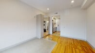 Located in the heart of Richmond, Virginia, this thoughtfully designed single-floor unit at 703 E Main St blends modern finishes with warm, characterful details. The main living area showcases a striking combination of polished concrete and rich hardwood flooring, creating a dynamic visual contrast that adds depth and texture to the open layout. Crisp white walls and recessed lighting throughout keep the space feeling bright and airy.

The kitchen is outfitted with sleek gray cabinetry, stainless steel appliances, and clean countertops, offering a functional and contemporary workspace. A dedicated in-unit laundry area adds everyday convenience. A mirrored wardrobe unit in the main area enhances the sense of space while providing practical storage.

The bathroom features elegant marble-style tile spanning both the walls and floor, complemented by matte black hardware accents and a glass-enclosed shower, lending a polished, upscale feel. The bedroom area is generously proportioned with warm hardwood floors and two large windows fitted with roller shades, framing expansive views of the Richmond cityscape — a standout feature that fills the room with natural light and a strong sense of place. The overall ambiance is clean, modern, and move-in ready.