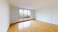 Located at 100 Eighth Avenue in Kitchener, Ontario, this 1-bedroom, 1-bathroom unit offers a clean and functional layout across a single floor. The living room is a standout space, highlighted by gleaming parquet wood flooring and a large sliding glass door that opens onto a private balcony with expansive city views, filling the room with natural light and a sense of openness.

The kitchen features white cabinetry with modern black hardware, marble-look countertops wrapping around in an L-shape, and a stainless steel range, all complemented by a window that brings in additional natural light.

The bedroom is generously sized, offering dual closets with full-length bi-fold doors for ample storage. A window provides natural light, and the same warm parquet flooring flows throughout, maintaining a cohesive aesthetic across the unit.

The bathroom is finished in crisp white, with full tile surround on the tub-shower combination, a vanity with marble-look countertop, and terrazzo-style flooring, creating a clean and timeless look.

A hallway connects all rooms efficiently, and baseboard heating units are present throughout. The consistent parquet flooring and bright white walls give the entire unit a warm yet airy ambiance.