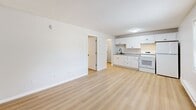 Located at 2011 3rd Ave SE in Aberdeen, South Dakota, this efficient one-bedroom, one-bathroom unit is thoughtfully laid out across a single floor. Light wood-look flooring runs throughout the space, creating a clean and cohesive aesthetic complemented by neutral wall tones and textured ceilings.

The open-concept living, dining, and kitchen area forms the heart of the unit. The kitchen features white cabinetry, a white electric range, a black sink fixture, and light stone-style countertops, all lending a fresh and functional feel. The adjoining living and dining space offers a bright, versatile area suitable for both relaxing and entertaining.

The bedroom is a well-proportioned private retreat, equipped with a built-in closet featuring bi-fold panel doors and benefiting from a window that allows natural light to filter in. Baseboard heating and a wall-mounted air conditioning unit ensure year-round climate comfort. An additional louvered bi-fold closet is accessible from the hallway, providing convenient storage.

The bathroom is neatly appointed with a full tub-and-shower combination, surrounded by large-format beige tile. A vanity with a granite-style countertop, a grey cabinet base, and wood-look flooring complete the space with a tidy, modern touch. A connecting hallway ties all rooms together in a practical and efficient layout.
