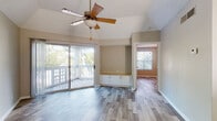 Located in Tampa, Florida, this single-story home on Deerbrooke Creek Circle offers a well-designed open layout with consistent wood-look flooring throughout. The living areas feature vaulted ceilings accented by ceiling fans, creating an airy and comfortable atmosphere. Large sliding glass doors in the main living space open directly onto a private outdoor deck, flooding the interior with natural light and providing seamless access to the outdoors. A built-in storage cabinet with a countertop adds a functional and charming detail to the living room.

The open-concept kitchen is equipped with white cabinetry, a dark granite-style countertop, white appliances including a range and refrigerator, and a breakfast bar that connects to the living and dining areas. An in-unit stacked washer and dryer is conveniently located just off the kitchen. The bedrooms are well-proportioned, each with ceiling fans and windows that invite natural light and outdoor views of surrounding greenery. The bathroom features a soaking tub with a tiled surround, white cabinetry with a granite-style countertop, and wood-look flooring, offering a clean and functional design. Neutral tones and consistent finishes throughout create a cohesive, move-in-ready feel.