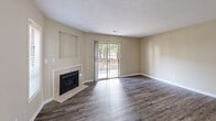 Located at 2221 Hyde Dr in Greenville, NC, this single-floor, 2-bedroom, 2-bathroom home offers a well-designed layout with a comfortable blend of function and style. The living room serves as the centerpiece of the home, featuring dark hardwood-style flooring, a tile-surround fireplace, and sliding glass doors that open to the outdoors, filling the space with natural light and views of the surrounding greenery. The kitchen is equipped with warm honey-toned cabinetry, dark granite countertops, a double-basin sink, and black appliances including a range and refrigerator, complemented by durable wood-style flooring. A closet off the kitchen provides convenient additional storage. The primary bedroom is generously sized, featuring plush carpeting, neutral warm-toned walls, and a walk-in closet with wire shelving. Its en-suite bathroom is a standout, offering a jetted soaking tub, a separate walk-in shower, and wood-style flooring. The second bedroom also features carpet flooring and a bright window with outdoor views. The second bathroom includes a tub-shower combination and a wood-vanity with a white countertop. A dedicated utility room and two closets round out the functional offerings of this well-appointed home.
