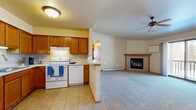 Located at 1405 N McCarthy Rd in Appleton, Wisconsin, this two-bedroom, one-bathroom home offers a well-designed single-floor layout with a comfortable and functional living experience. The open-concept main living area seamlessly connects the kitchen, dining, and living spaces, creating a bright and inviting atmosphere. The kitchen features warm oak cabinetry, tile flooring, a peninsula with a breakfast bar, and white appliances including a range, dishwasher, and refrigerator. The living room is generously sized, finished with plush carpeting, a ceiling fan, and a tiled fireplace with a wood mantle as a central focal point. Sliding glass doors lead directly to a private balcony, bringing in natural light and outdoor views. Both bedrooms are carpeted and include natural light from windows and baseboard heating, with the primary bedroom featuring a ceiling fan. The full bathroom includes a wood-toned vanity, tile flooring, and a tub-shower combination. A second half-bath provides added convenience. The home also includes in-unit laundry and five closets throughout, offering exceptional storage. Warm neutral tones and wood accents give the space a cohesive, welcoming character throughout.