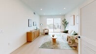 Located in the heart of Los Angeles, this modern single-story residence on Gramercy Drive offers a thoughtfully designed layout with clean lines and contemporary finishes throughout. Light hardwood flooring flows seamlessly across the entire space, complementing the crisp white walls and recessed lighting that create a bright, airy atmosphere.

The open-concept living room is a welcoming centerpiece, bathed in natural light from a large sliding glass door that opens directly onto a generous outdoor terrace. This expansive balcony offers sweeping views of the Los Angeles skyline, palm trees, and the surrounding hillsides — an ideal space for outdoor relaxation. The kitchen is well-appointed with stainless steel appliances, two-tone cabinetry featuring warm wood lower cabinets and muted upper cabinets, light quartz countertops, under-cabinet lighting, and an in-unit stacked washer and dryer.

The bedroom is a serene retreat with a corner window that draws in natural light, while the dedicated walk-in closet provides generous storage with built-in hanging rods and shelving. The full bathroom features a soaking tub with shower, chrome fixtures, and a clean, minimalist design. A connecting hallway ties all rooms together efficiently, making the most of the well-proportioned floor plan.